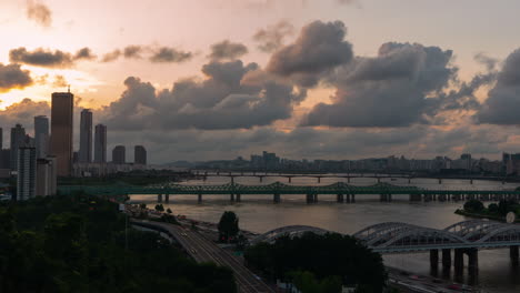 Beautiful-Dramatic-Sky-Sunset-Over-Han-River-Overlooking-Many-Bridges,-63-Building-and-Car-Traffic-Time-Lapse-on-Olympic-Expressway,-at-Yeouido-District-in-Seoul-City,-South-Korea---pan-reveal