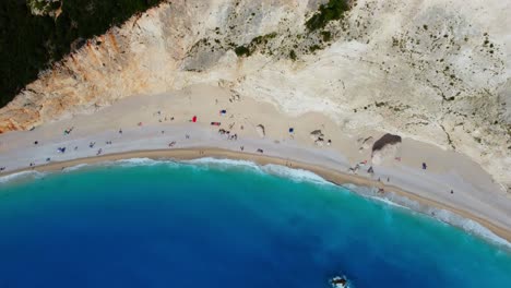 Drone-shot-of-Porto-Katsiki-beach-in-Lefkada-with-crystal-clear-sea-water-surrounded-by-white-mountains