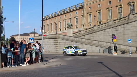 Police-car-with-blinking-lights-drives-by-Swedish-Royal-Palace-on-National-Day