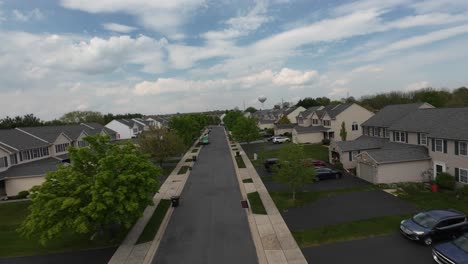 Drone-flight-over-street-in-american-housing-area-with-garage-and-parking-cars