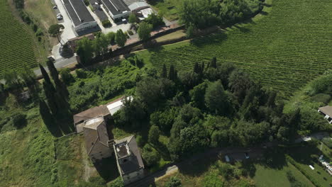 Abandoned-villa-surrounded-by-lush-greenery-in-Italy,-captured-from-above,-sunny-day