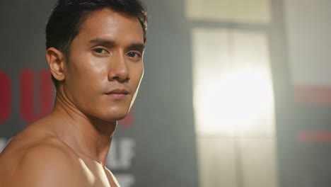 Portrait-of-Asain-sportsmale-shirtless-exercising-in-fitness-gym-club.-Attractive-athlete-young-man-standing-and-crossing-arms-after-finished-working-out-with-machines-and-equipment-in-gymnasium-club.