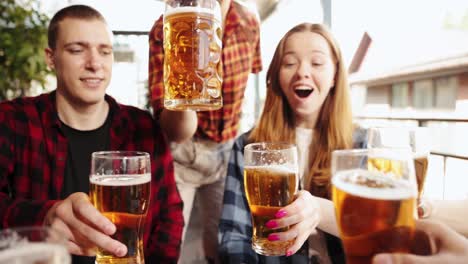 Group-of-cheerful-young-people,-friends-meeting-at-cafe,-pub,-spending-time-together,-drinking-beer.-Celebration-and-fun.-Concept-pktoberfest,-traditional-taste,-friendship,-leisure-time,-enjoyment