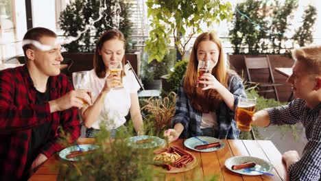 Young-delightful-people,-friends-meeting-at-pub-in-sunny-day,-drinking-lager-beer,-celebrating-festival,-having-fun.-Concept-of-oktoberfest,-traditional-taste,-friendship,-leisure-time,-enjoyment