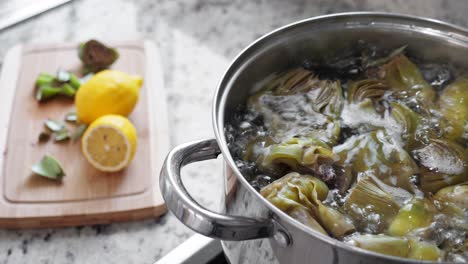 Boiling-and-cooking-artichokes-in-saucepan,-closeup