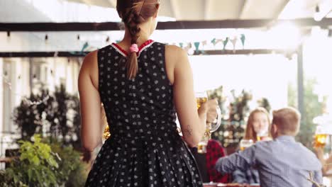 Beautiful,-smiling,-young-woman,-waitress-serving-big-mugs-with-lager-beer-to-group-of-young-people,-friends-at-pub.-Oktoberfest,-traditional-taste,-friendship,-leisure-time,-enjoyment-concept