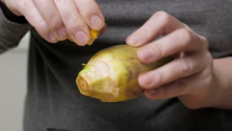 Woman-cleaning-artichokes.-Dropping-lemon-drops.-Cooking-process-at-the-kitchen.-Closeup