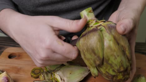 Woman-cleaning-artichokes.-Cooking-process-at-the-kitchen.-Closeup