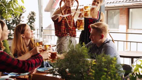 Young-stylish-people-in-bavarian-clothes-drinking-beer-and-eating-lager-beer-at-pub.-Friends-meeting-for-celebration.-Concept-of-oktoberfest,-traditional-taste,-friendship,-leisure-time,-enjoyment