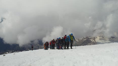 Rusia,-Elbrus.-Los-Escaladores-Suben-Por-Una-Pendiente-Rocosa-Cubierta-De-Nieve.