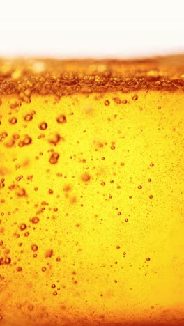 Close-up-of-beer-pouring-into-glass.-Lager-foamy-beer-with-big-bubbles-rising-upwards.-Hop-taste.-Concept-of-beer-drink,-brewery,-taste,-bar,-degustation,-festival,-drink-texture.-Vertical-layout