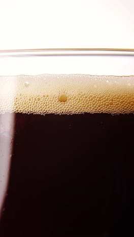 Delicious,-cool,-foamy-dark-beer-pouring-into-glass,-bubbles-rising-upwards.-Hop-taste.-Concept-of-beer-drink,-brewery,-taste,-bar,-degustation-and-festival,-drink-texture.-Vertical-layout