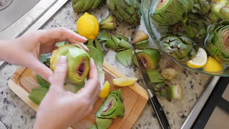 Woman-peeling-artichokes.-Cooking-process-at-modern-kitchen