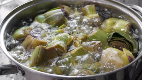 Boiling-and-cooking-artichokes-in-saucepan,-closeup