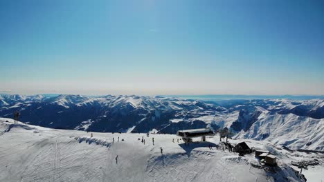 Unrecognizable-tourists-riding-from-snowy-hill-top.