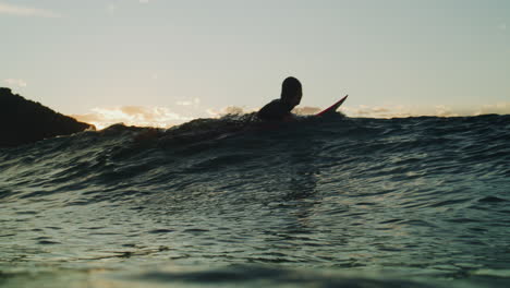 Surfer-kicks-and-paddles-over-wave-building-up,-underwater-green-mystical-sunlight-texture