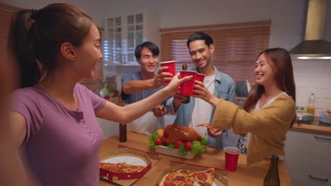 Group-of-Asian-friend-having-dinner,-enjoy-evening-party-together-at-home.-Attractive-young-man-and-woman-having-fun,-eating-food,-celebrate-weekend-reunion-gathered-together-at-dining-counter-at-home