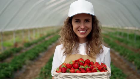 Beautiful-smiling-woman-holding-ripe-and-fresh-strawberry.