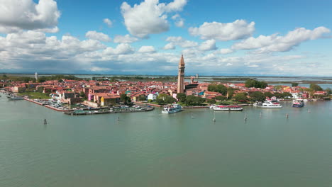 Vista-Aérea-De-La-Isla-De-Burano,-Italia,-Con-Sus-Edificios-Vibrantes,-Su-Puerto-Y-Su-Icónica-Torre-Inclinada.