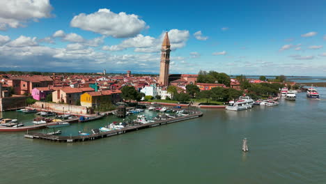 Stunning-aerial-footage-of-Burano’s-vibrant-waterfront,-iconic-bell-tower,-and-surrounding-lagoon-in-Venice,-Italy