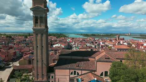 Una-Impresionante-Vista-Aérea-De-Burano-Que-Muestra-Su-Torre-Inclinada,-Sus-Casas-Vibrantes-Y-Sus-Canales-Pintorescos.