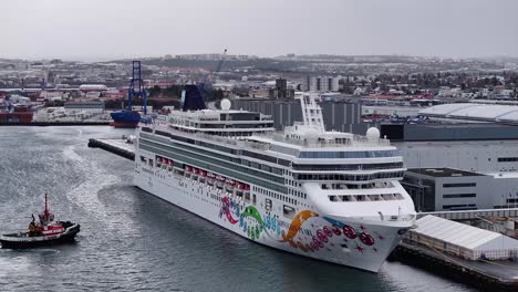 Ein-Großes-Kreuzfahrtschiff,-Die-MSC-Norwegian-Pearl,-Liegt-Im-Hafen-Von-Reykjavik-Und-Bereitet-Sich-Auf-Die-Abfahrt-Vor,-Im-Hintergrund-Sieht-Man-Einen-Geschäftigen-Hafen-Und-Die-Stadt