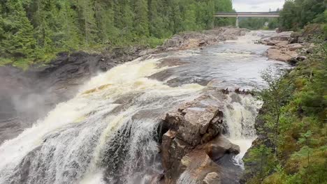 Ein-Atemberaubender-Wildwasser-Gebirgsfluss-Fließt-Mit-Gewaltiger-Kraft-In-Der-Nähe-Von-Grong,-Norwegen-Und-Erzeugt-Atemberaubende-Wasserfälle-Inmitten-Des-Zerklüfteten-Geländes