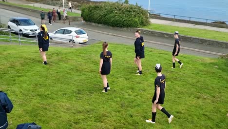 Grupo-De-Danza-Galesa-Practicando-Una-Rutina-De-Baile-Con-Bastón-En-Formación-En-El-Paseo-Marítimo-De-Holyhead