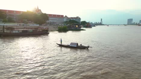 Luftaufnahme-Eines-Fischers,-Der-Bei-Sonnenuntergang-In-Einem-Traditionellen-Boot-Auf-Dem-Mekong-In-Der-Stadt-Phnom-Penh-Fische-Fängt