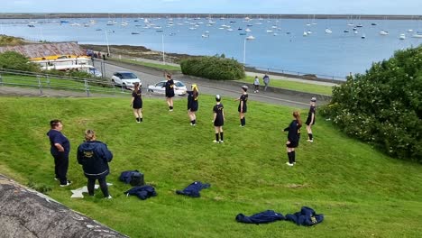 Young-adult-Welsh-dance-troop-practicing-formation-baton-dancing-performance-on-Holyhead-waterfront