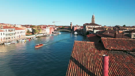 Captivating-aerial-footage-of-Murano’s-picturesque-canals,-historic-bell-tower,-and-charming-buildings-in-Venice,-Italy