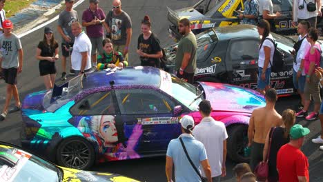 Female-pilot-handing-gifts-and-talking-to-fans-during-the-car-exhibition