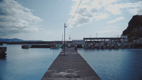 Tranquil-marina-harbor-in-Saikazaki,-Japan-featuring-docked-boats-against-a-backdrop-of-clear-skies-and-calm-waters