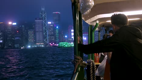 Menschen-Machen-Eine-Nächtliche-Fahrt-Mit-Der-Star-Ferry,-Im-Hintergrund-Ist-Die-Skyline-Von-Hongkong-Zu-Sehen