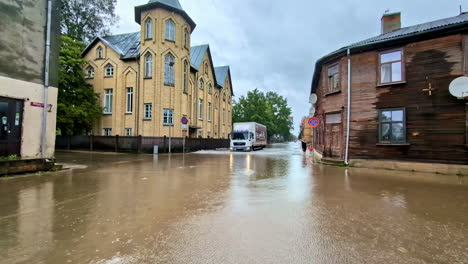 Truck-driving-through-flooding-streets,-aftermath-of-torrential-rains-in-Latvia