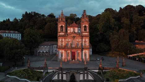 Bom-Jesus-church-lit-by-sunset,-surrounded-by-Minho's-lush-forest