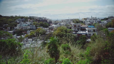 Vista-Panorámica-De-Las-Casas-Del-Pueblo-Ubicadas-En-Una-Ladera-En-Saikazaki,-Japón,-Que-Exhiben-Una-Arquitectura-Tradicional-Y-Una-Exuberante-Vegetación.