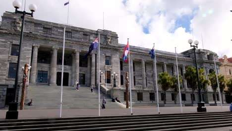 Vista-Exterior-Del-Edificio-Del-Parlamento-De-Nueva-Zelanda-Con-Banderas-En-La-Ciudad-Capital-De-Wellington,-Nueva-Zelanda-Aotearoa