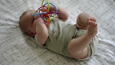 Baby-Caucasian-boy-playing-with-a-colorful-toy-on-a-play-mat