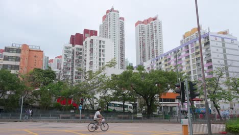 Ein-Mann-Fährt-Mit-Dem-Fahrrad-Durch-Den-Rahmen-Vor-Einem-Hochhaus-Mit-Sozialwohnungen-In-Hongkong