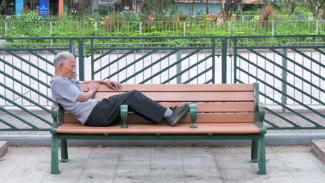 Un-Anciano-Chino-Descansa-En-Un-Banco-Público-En-Un-Parque-De-Hong-Kong.