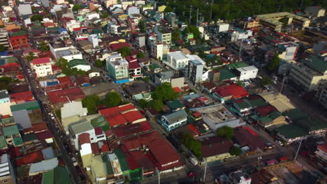 Drone-flying-over-the-vibrant-homes-of-Makati-city,-sunny-morning-in-Philippines