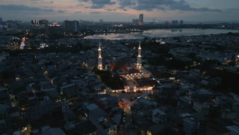 Mezquita-Islámica-Por-La-Noche-En-Pluit,-Al-Norte-De-Yakarta,-Con-Drones-Descendiendo-En-25-Fps