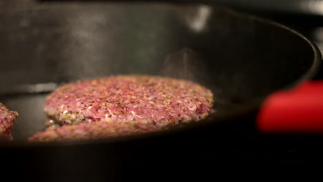 Burgers-cooking-on-cast-iron-pan,-close-up,-smoking,-grilling,-meat,-american,-bbq,-food,-diet,-protein