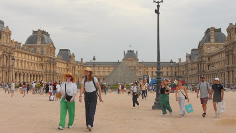 People-stroll-near-the-Louvre-Museum-in-Paris-on-a-cloudy-day