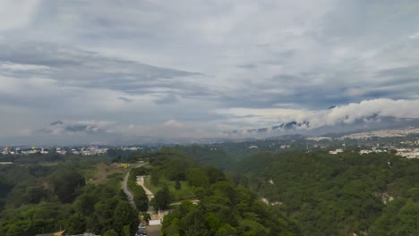 Ein-Atemberaubender-Hyperlapse,-Der-Einen-Bewölkten-Tag-In-Guatemala-Stadt-Zeigt,-Mit-Dramatischen-Wolken,-Die-Die-Vulkane-Im-Hintergrund-Einhüllen