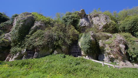 Extra-Wide-Straight-on-shot-of-the-limestone-gorge-with-caged-entrance-to-the-caves-at-Creswell-Crags