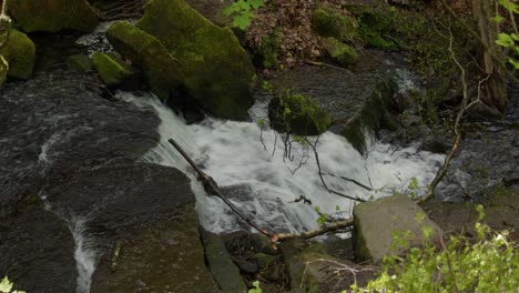 wide-shot-looking-down-at-Lumsdale-waterfalls-with-rocks-and-vegetation-in-foreground-at-Lumsdale,-Matlock