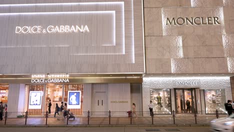 Fußgänger-Gehen-Nachts-In-Hongkong-An-Den-Geschäften-Der-Italienischen-Luxusmodemarken-Dolce-Und-Gabbana-Und-Moncler-Vorbei