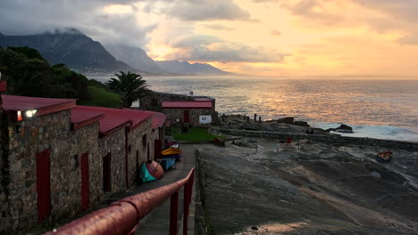 Vista-Vibrante-Del-Amanecer-Sobre-El-Océano-Desde-Los-Edificios-Históricos-Del-Antiguo-Puerto-De-Hermanus